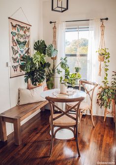 a living room with wooden floors and plants in the window sill on the wall