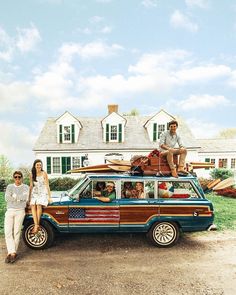 two people sitting on the roof of a van with an american flag painted on it