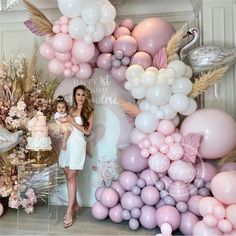 a woman and child standing in front of balloons