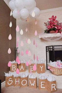 a baby shower party with pink and white balloons hanging from the ceiling, paper raindrops