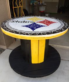 a yellow table with a black base and a red, white, and blue star on it