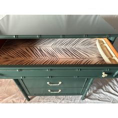 a green painted dresser with drawers and an open drawer