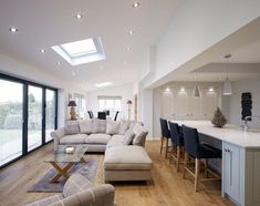 a living room filled with furniture next to a kitchen