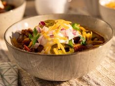 a bowl filled with chili and cheese on top of a table