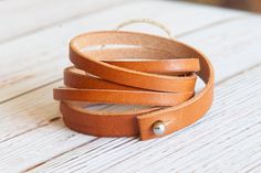 Handcrafted Leather Bracelet Beautiful vegetable tanned, full grain leather, hand cut and finished. This leather is so gorgeous! I create each piece to order. These classic bracelets can go with just about anything in your wardrobe. Dress them up or down! The bracelet wraps around three times and closes with a brass button stud. The center hoop is handcrafted sterling silver hoop is approx. 1.5 inches wide and it's attached with brass rivets. Make sure to measure your wrist at the smallest point. Using string works best and make sure it's not loose or tight. I add extra length to your wrist size to ensure it's the perfect fit. Each piece is sealed with high quality, natural sealant to ensure it's durability. The bracelet should not be submerged in water. If the bracelet is exposed to water Boho Style Bracelets, Classic Bracelets, Handmade Gifts For Her, Hammered Silver, Handcrafted Leather, Sterling Silver Hoops, Leather Wraps, Handmade Sterling Silver, Silver Hoops