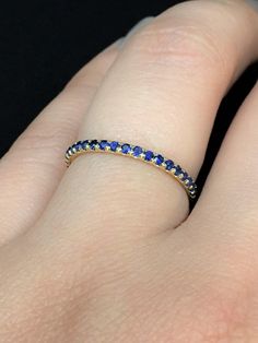 "Delicate Royal Blue Sapphire Gemstone Micro Pave Full Eternity Band Ring. MaterialSolid Gold 14K or 18K PlatingRhodium/ Platinum Family (Only if white gold selected) FinishHigh Polished/ Shiny FitComfort Fit/ Rounded Interior Width1.5mm Height1.5mm SettingU Micro Pave Set (Reminds the letter \"U\" from sides) StoneNatural Blue Sapphire Stone CutDiamond Cut, Round Total Carat Weight0.53 ct Quantity of Stonesapx 42 (varies by ring size) QualityAAA Click below to add laser engraving. https://www.e Blue Round Eternity Band With Prong Setting, Yellow Gold Sapphire Round Eternity Band, Blue Diamond Stackable Eternity Band, Gold Sapphire Eternity Band With Prong Setting, Blue Half Eternity Round Band, Blue Half Eternity Band, Stackable Yellow Gold Sapphire Eternity Band, Yellow Gold Sapphire Stackable Eternity Band, Stackable Sapphire Eternity Band In Yellow Gold