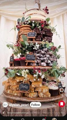 a wedding cake made out of cupcakes and pastries on a tree stump