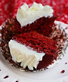 two red velvet cupcakes with white frosting