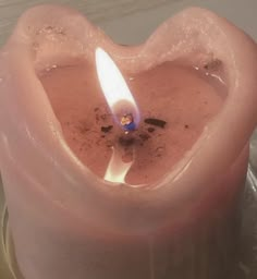 a heart shaped candle with a lit candle in it