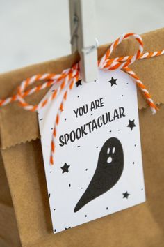 a brown paper bag with an orange and white string tied around it that says, you are spooktacular