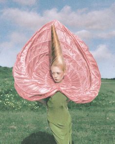 a woman in a green dress is holding a pink umbrella over her head while standing on the grass