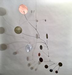 a metal sculpture with several different colored discs hanging from it's centerpieces