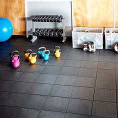 there are many pairs of kettles in the gym with exercise balls on the floor