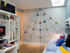 a room with a bed, television and shelves filled with bookshelves in it