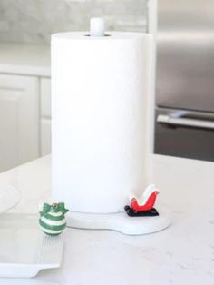 a roll of toilet paper sitting on top of a counter next to a toothbrush