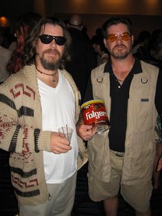 two men standing next to each other at a party