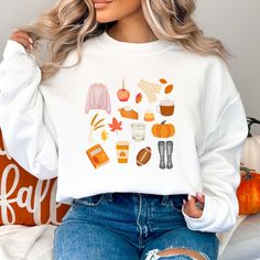 A Few of My Favorite ThingsFall Edition.  This adorable sweatshirt contains all my favorite fall things-- from boots, sweaters, and scarves to candles, books, and even football! There is something for every fall loving girly in this adorable sticker.  DTF on Gildan 18000 white sweatshirt. Recommend machine wash cold inside out. Gildan 18000 sweatshirts run true to size. If you'd like an oversized fit, I'd recommend ordering up a size or two. Sweatshirt details: 50% Cotton, 50% Polyester pill-resistant air jet yarn double-needle stitching throughout set-in sleeves 1x1 ribbed collar, cuffs and waistband with spandex Sweatshirt Preppy, Sweatshirt Details, Fall Things, Preppy Fall, Cute Fall Outfits, Fall Favorites, Fall Sweatshirt, White Sweatshirt, Air Jet