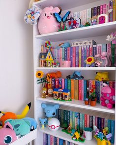 a book shelf filled with lots of books next to a stuffed animal and other toys