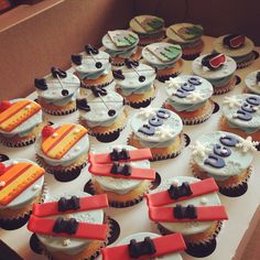 many cupcakes are arranged on a table with ribbons and bows in the shape of numbers