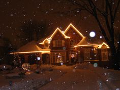 a house covered in christmas lights and snow