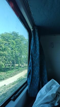 the view from inside a train looking out at trees