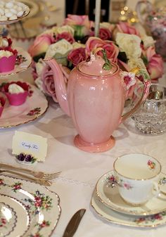 a table topped with plates and cups filled with flowers