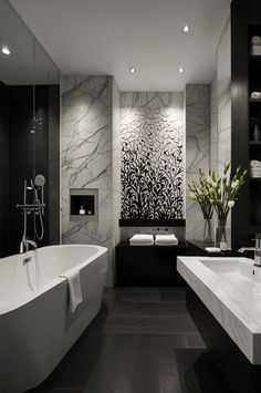 a large bathroom with black and white decor on the walls, flooring and tub