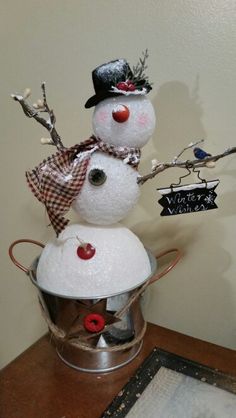 a snowman is sitting in a bucket on the table