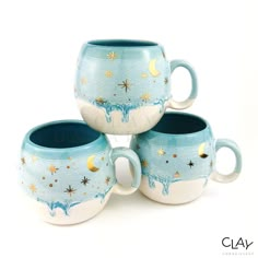 three coffee mugs sitting next to each other with stars and moon designs on them