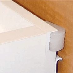 an open white box sitting on top of a wooden table next to a brown wall