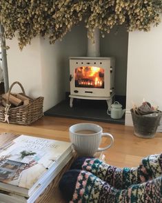 a cup of coffee sitting on top of a wooden table next to a fire place