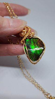 Natural Canadian gem stone Ammolite mined in northern Alberta Canada Gem status was granted in 1981 by the gem society and a sought after stone due to its colour display with the light. This free form stone is quite substantial piece measured 23mmx18mm with bail total measure45mm 18 inch gold stainless laser cut chain Wire wrapped in 18k gilt tarnish resist wire in a OOAK design Ammolite believe to be an energy stone bring positive energy and good luck Energy Stones, Alberta Canada, Gold Wire, Green And Orange, Orange, Pendant, Gold