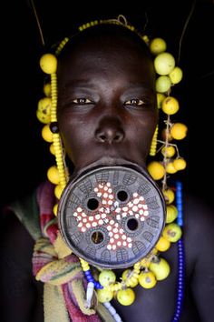 an african woman with beaded necklaces and cross on her face