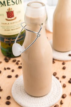 there is a glass bottle with some liquid in it on the table next to coffee beans