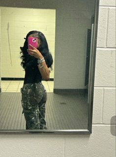 a woman taking a selfie in front of a mirror