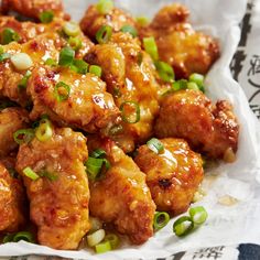 chicken wings with green onions and seasoning in a white paper wrapper on a table