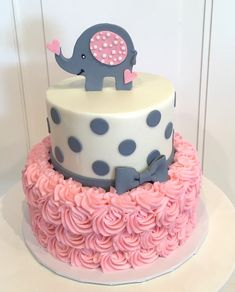 a pink and blue cake with an elephant on top