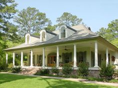 a large white house with columns on the front porch and covered in grass, surrounded by trees