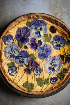 a pie with blue and yellow pansies on it