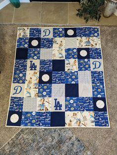 a baseball themed quilt on the floor in front of a plant and potted plant