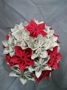 an origami ball made out of sheet music paper with red and white flowers