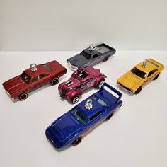 four toy cars are lined up on a table