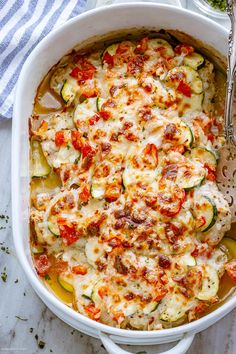 a casserole dish with zucchini, tomatoes and other vegetables in it