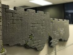 some kind of stone wall with moss growing on it's sides in an office cubicle