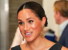 a woman in black dress smiling at the camera