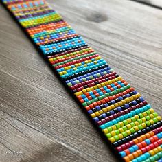 a colorful beaded bracelet sitting on top of a wooden table