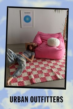 a woman laying on top of a pink bean bag chair next to a white rug