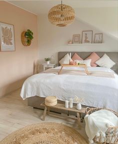 a bed sitting in a bedroom next to a wooden table and lamp hanging from the ceiling