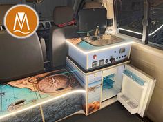 the interior of a vehicle with pictures on the floor and in front of it is a mini fridge