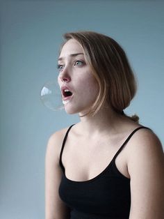 a woman blowing a bubble with her mouth